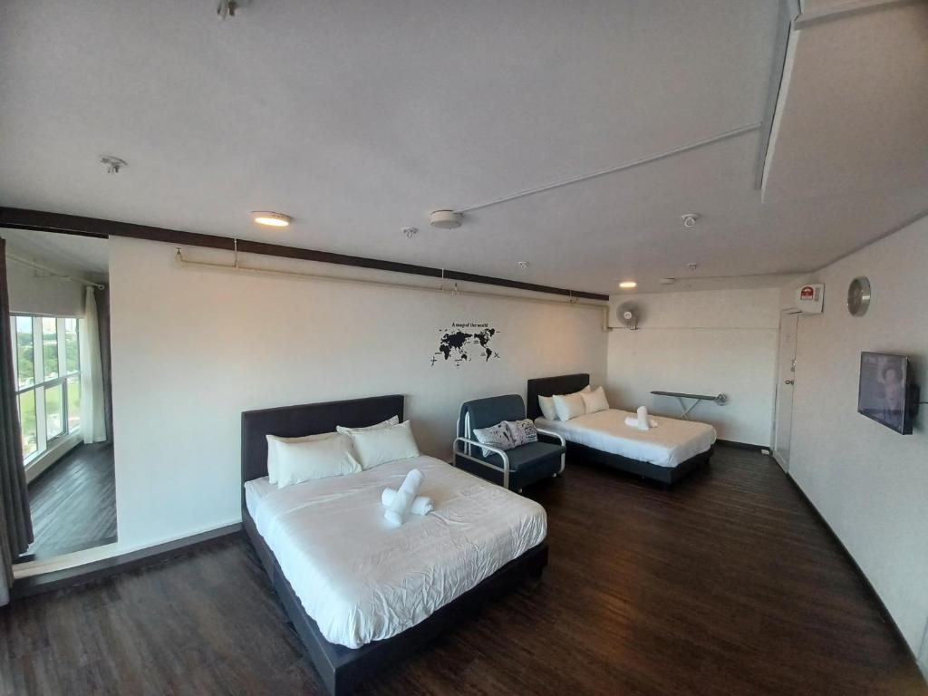 ein Hotelzimmer mit 2 Betten und einem Sofa in der Unterkunft SY Staycation - Apartment with Netflix in Bayan Lepas