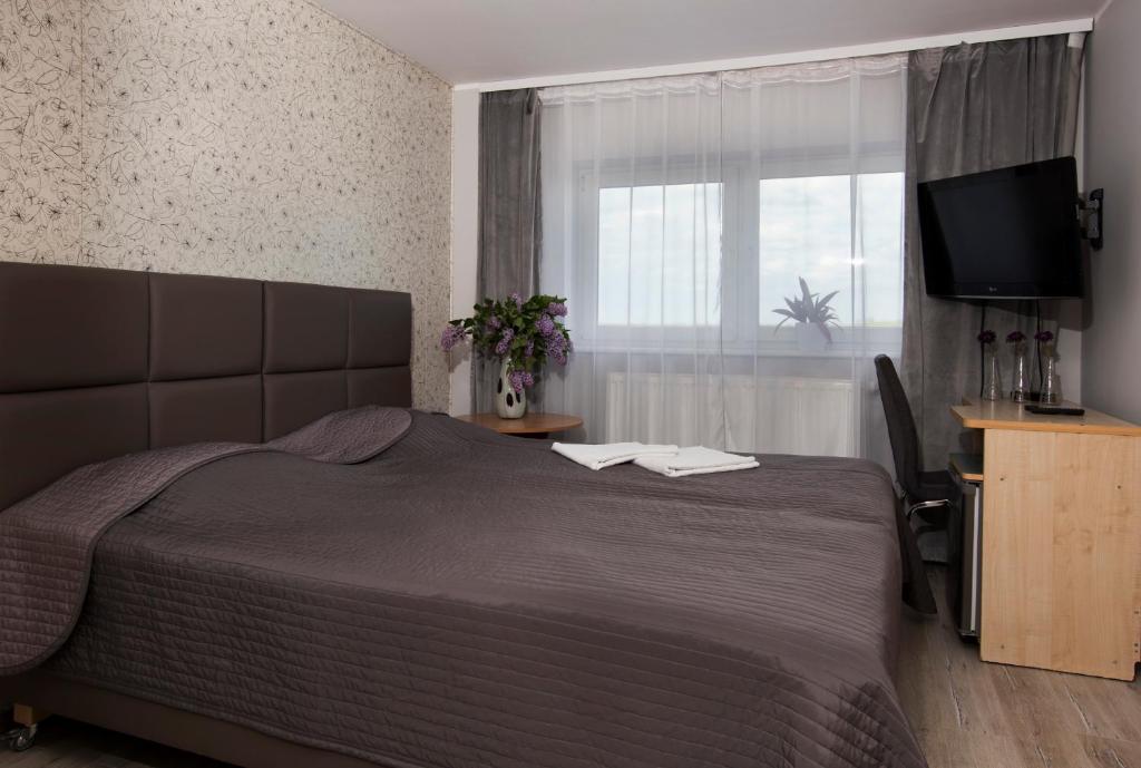 a bedroom with a large bed and a television at Western Hills in Gdańsk