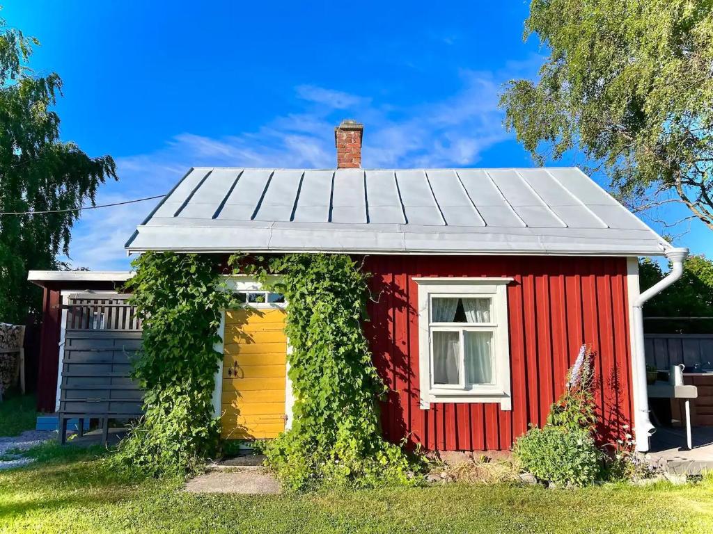 a red and yellow house with ivy around it at Abbis lillstuga in Norra Vallgrund
