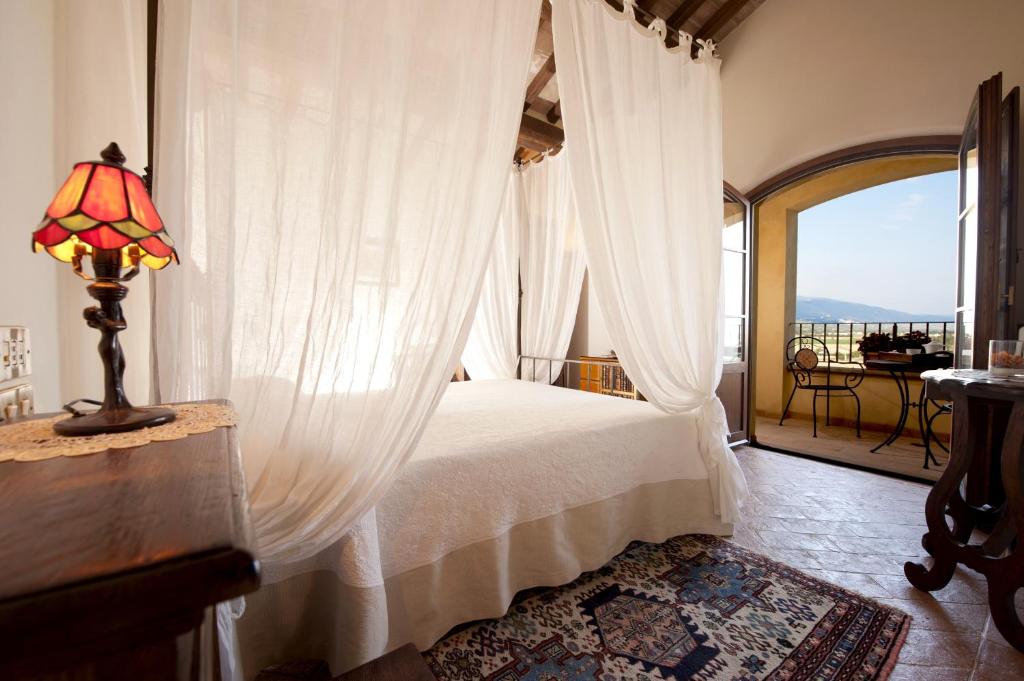 a bedroom with a canopy bed with a window at Ripa Relais Colle Del Sole in Torchiagina