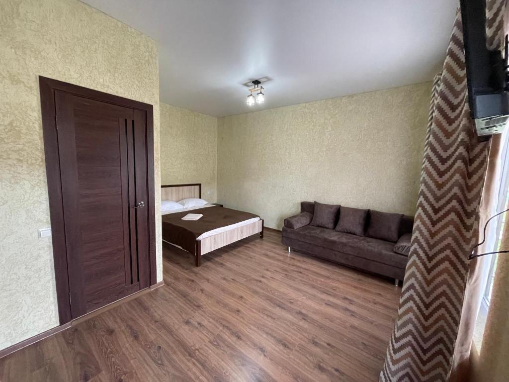 a small room with a bed and a couch at Guest House u Feliksa in Tsandrypsh