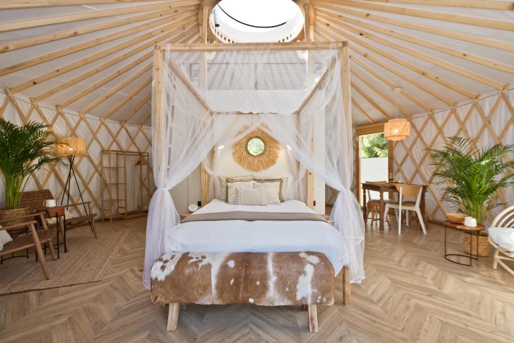 a bedroom with a canopy bed in a yurt at JURTLANDIA jurta BOHO in Lubiatowo