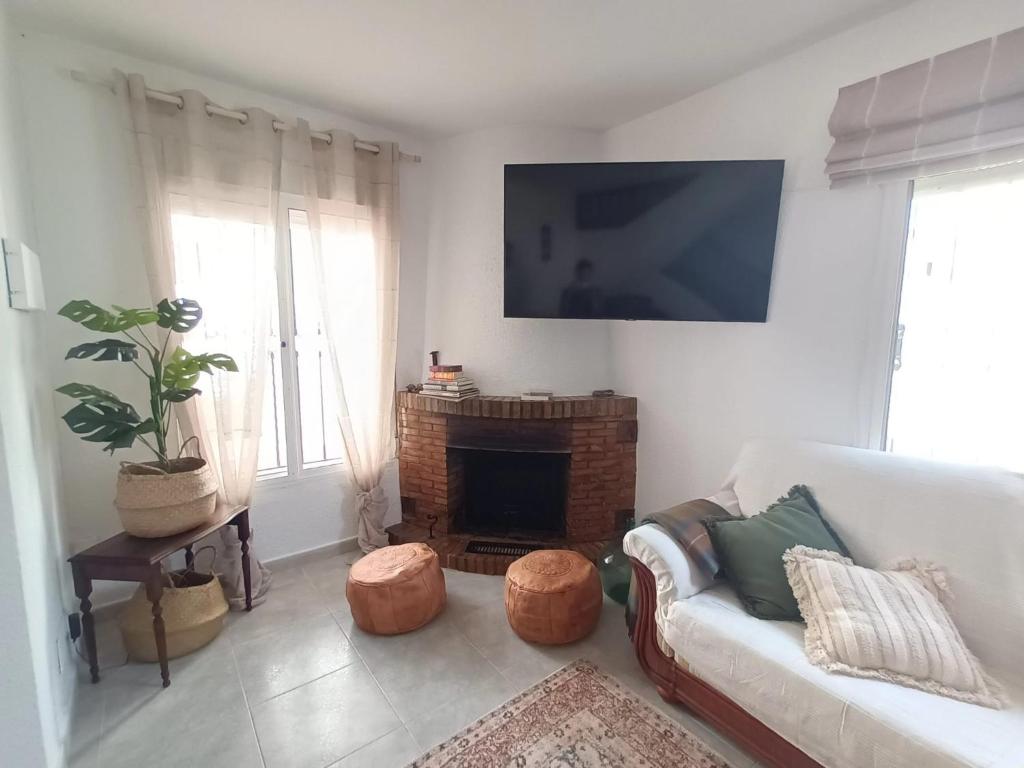 a living room with a couch and a fireplace at NUEVA NERJA Pueblo Andaluz Casa Grafton in Nerja