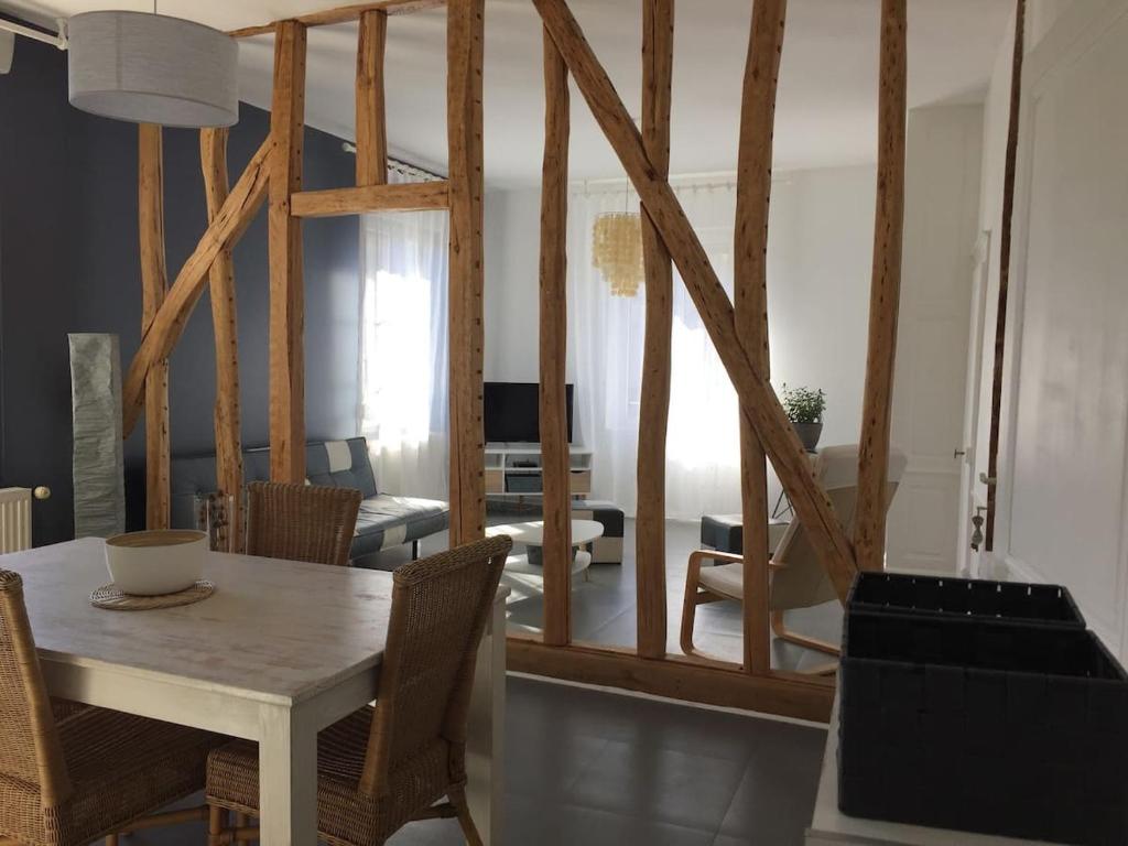 a dining room and living room with a table and chairs at Le Rameau in Sainte-Menehould