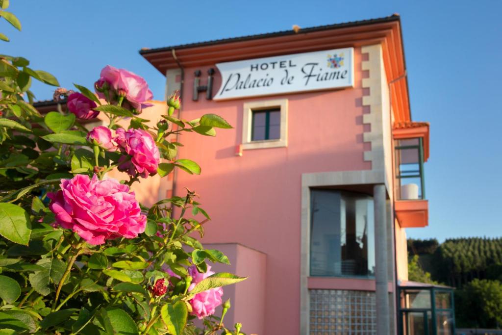 un edificio rosa con rosas delante en HOTEL PALACIO DE FIAME, en Verdicio