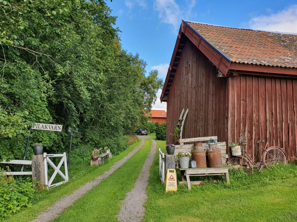 a dirt road next to a barn with a dirt road at Pilakvarn in Falköping