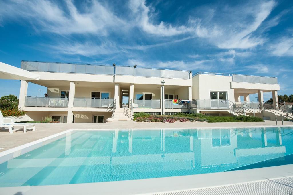 una casa con piscina di fronte a un edificio di Appartamenti Giglio di Mare a Policoro