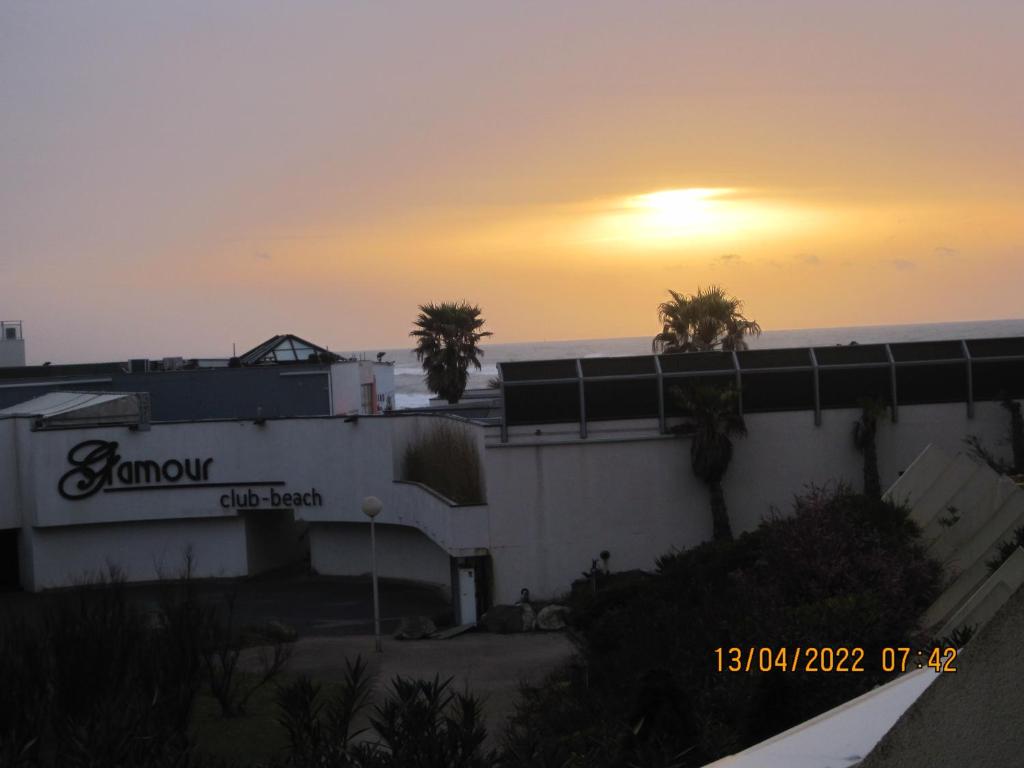 a building with the sun setting in the background at naturiste in Cap d'Agde