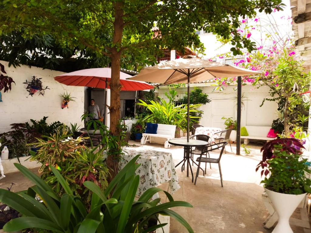 a patio with tables and chairs and umbrellas at Casa Zaida Hostal Vintage in Ríohacha