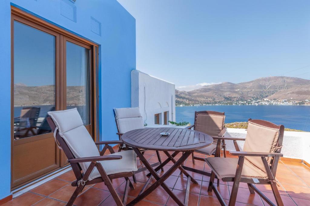 a table and chairs on a balcony with a view of the ocean at Stefanakis Villas - Car Included in Livadia