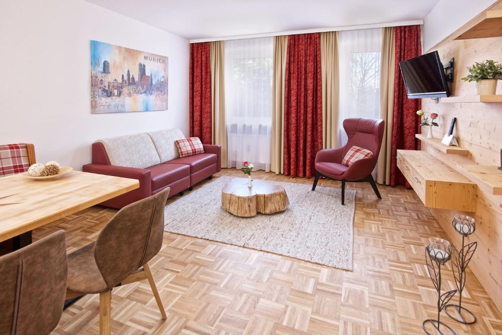 ein Wohnzimmer mit einem Sofa und einem Tisch in der Unterkunft Park Hotel Laim Serviced Apartments in München