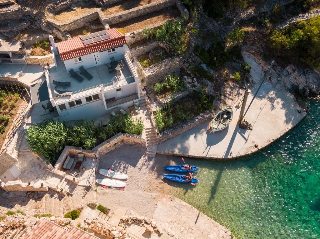 an aerial view of a house with boats in the water at Orsula's Beach House in Vela Luka