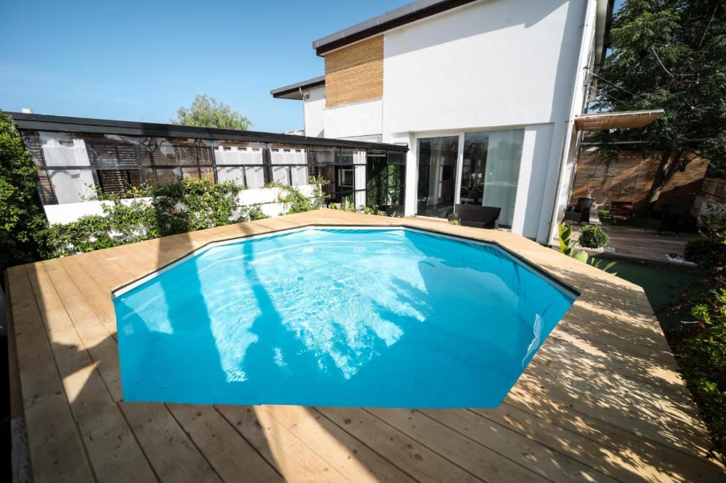 a swimming pool on a wooden deck next to a house at Essential suite in Casarano