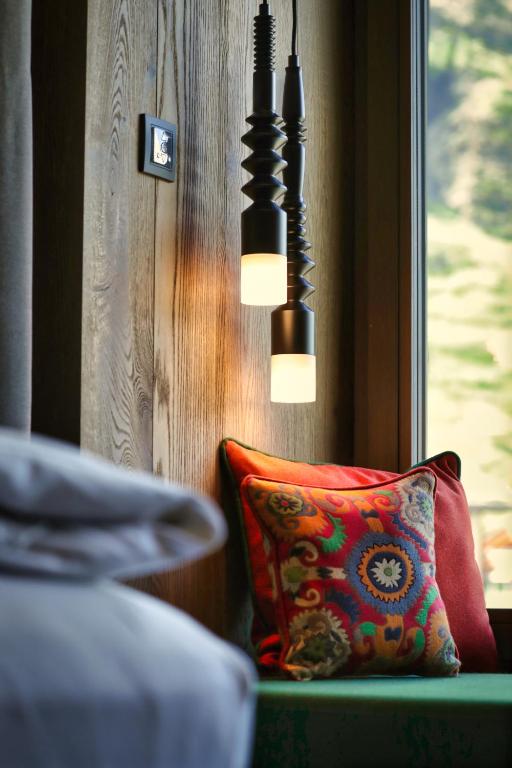 a pillow sitting on a bench next to a window at Hotel ZERMAMA Zermatt in Zermatt