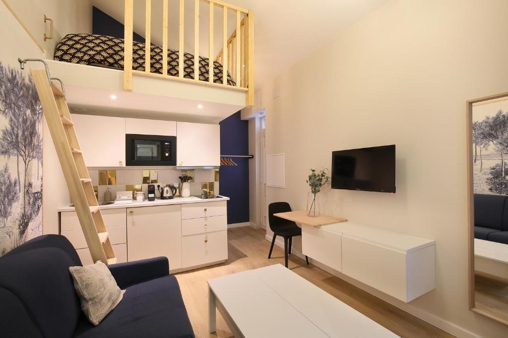 - un salon avec un canapé, un bureau et une télévision dans l'établissement La Chartreuse - Ravissant appartement à Toulouse, à Toulouse