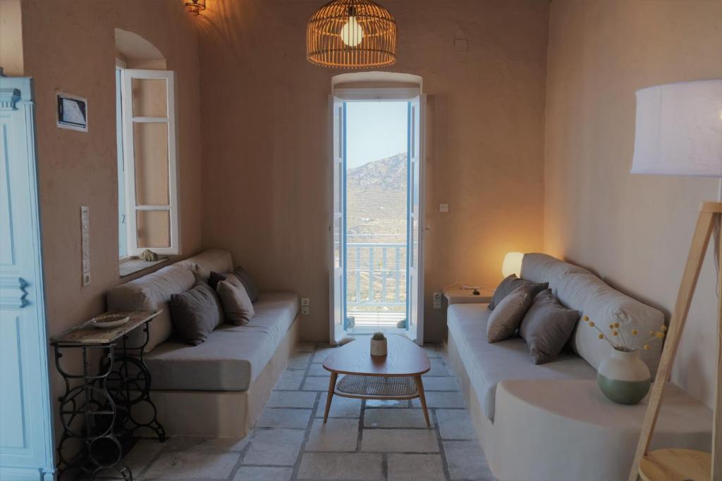 a living room with two couches and a large window at Salty Edge Holiday Home in Serifos Chora