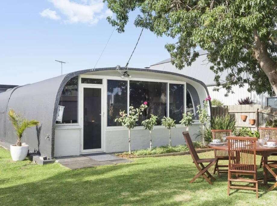 a small caravan with a table and chairs in a yard at Chill at our Igloo cottage - 100m stroll to beach in Portarlington