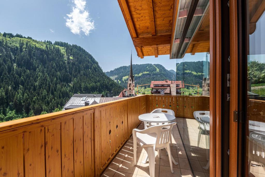 a balcony with a table and chairs and a view at Hotel Residence Gardena Stevia 307 in Santa Cristina Gherdëina