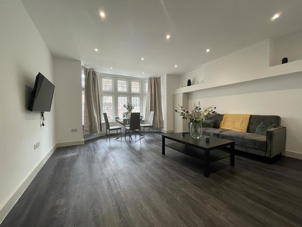 a living room with a couch and a table at Star London Finchley Road 3-Bed Retreat in London