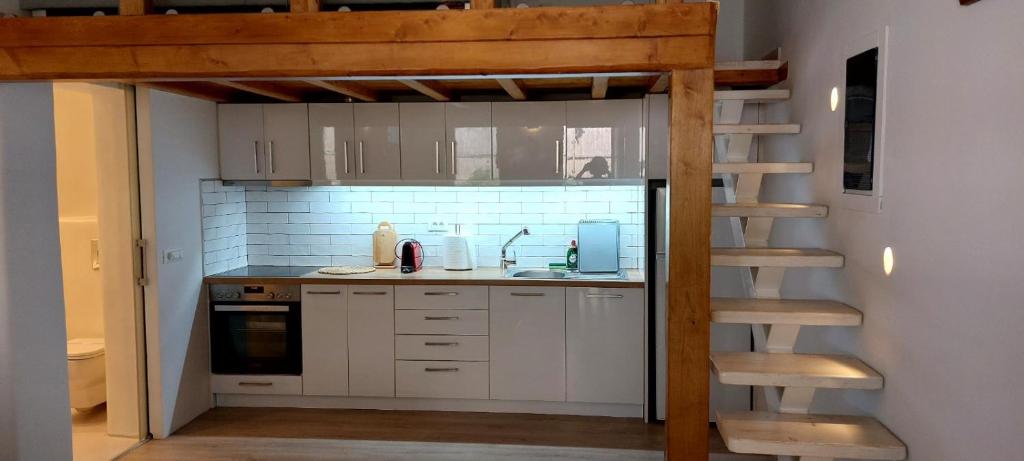 a kitchen with a loft bed and a kitchen with a staircase at Empyreal Blue Apartments in Dexamenes