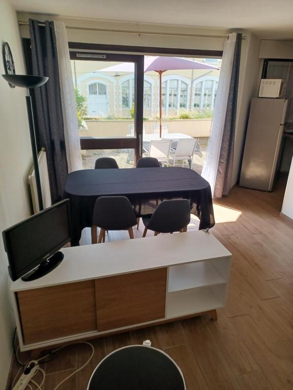 Cette chambre comprend un bureau, des chaises et une table. dans l'établissement T2 grande terrasse Wi-Fi parking gratuit, à Voiron