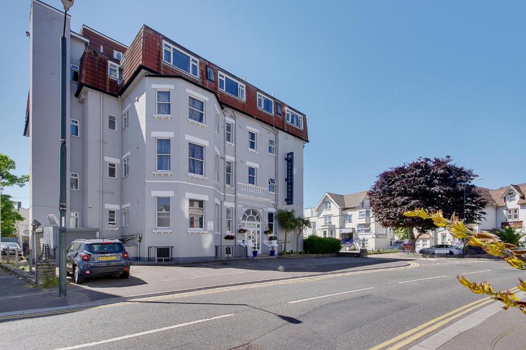 a white building with a car parked in front of it at Bourne Hall Hotel in Bournemouth