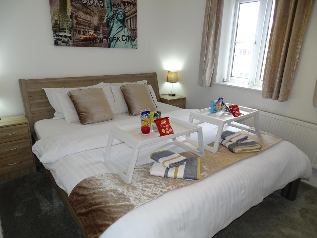 1 dormitorio con 1 cama blanca grande y 2 mesas en Ramskir Apartment, en Doncaster