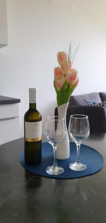 - une bouteille de vin et deux verres sur une table dans l'établissement Apartman MNA, à Split
