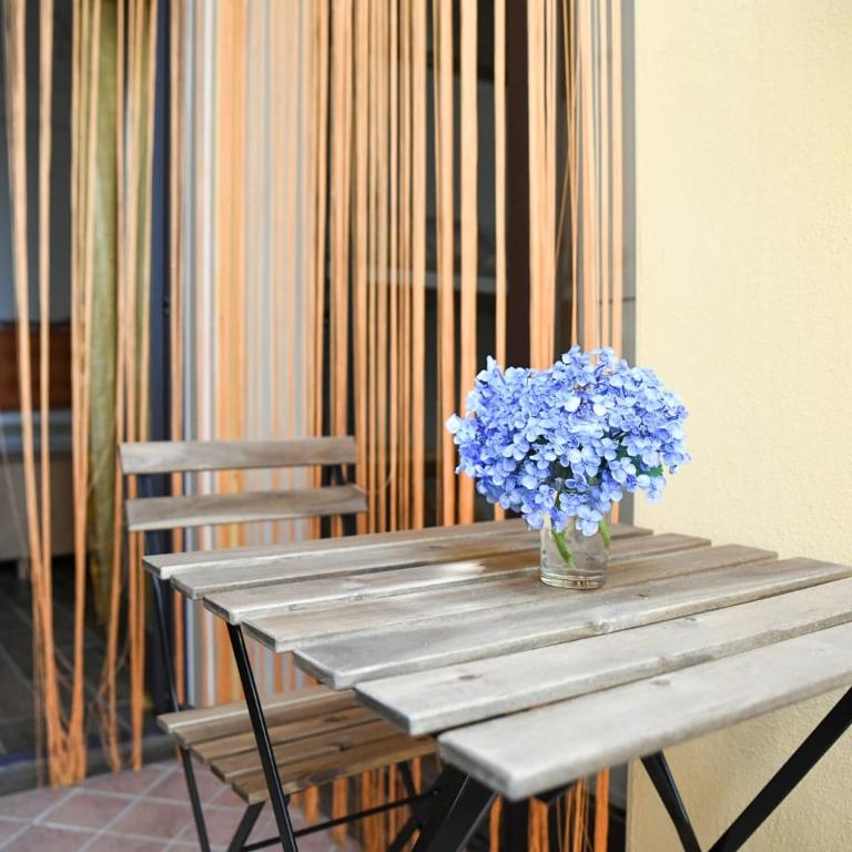 un vase de fleurs bleues assis sur une table en bois dans l'établissement A Villeggiatura, à Scilla