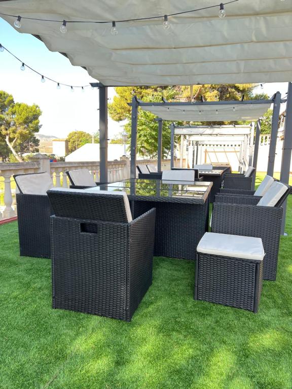 eine Terrasse mit Korbstühlen und einem Pavillon in der Unterkunft Hotel El Cisne in Saragossa