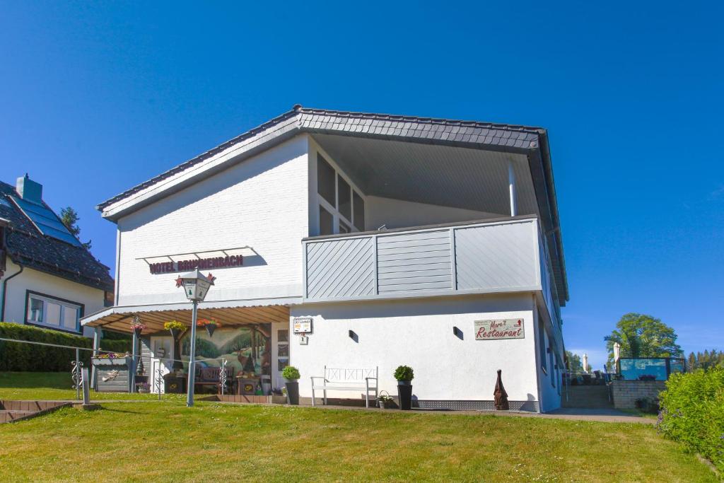 a white building with a balcony on the side of it at Hotel Brunnenbach in Braunlage