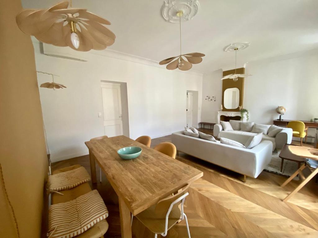 sala de estar con mesa y sofá en Appartement de maître T3 80m2 en plein centre., en Ajaccio