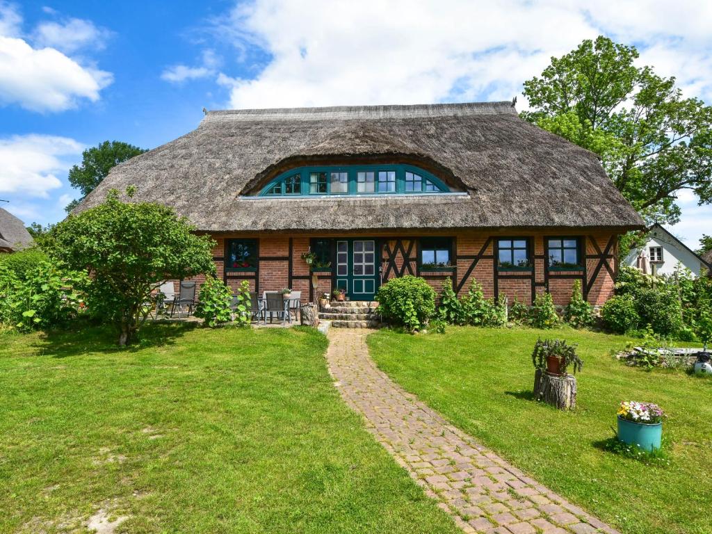een huis met een rieten dak en een grasveld bij Ferienwohnung Hugo nur 200 Meter bis zum Wasser in Putbus