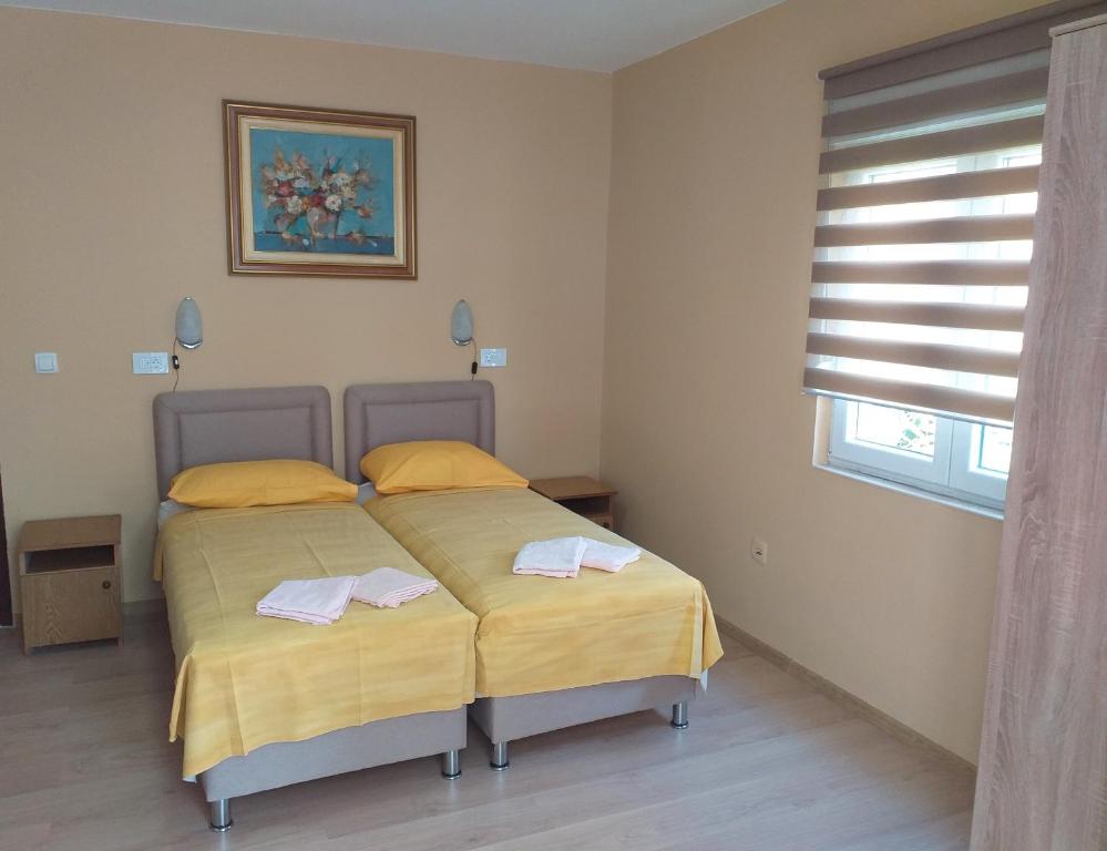 1 Schlafzimmer mit 2 Betten und einem Fenster in der Unterkunft Mirko Apartments Budva in Budva