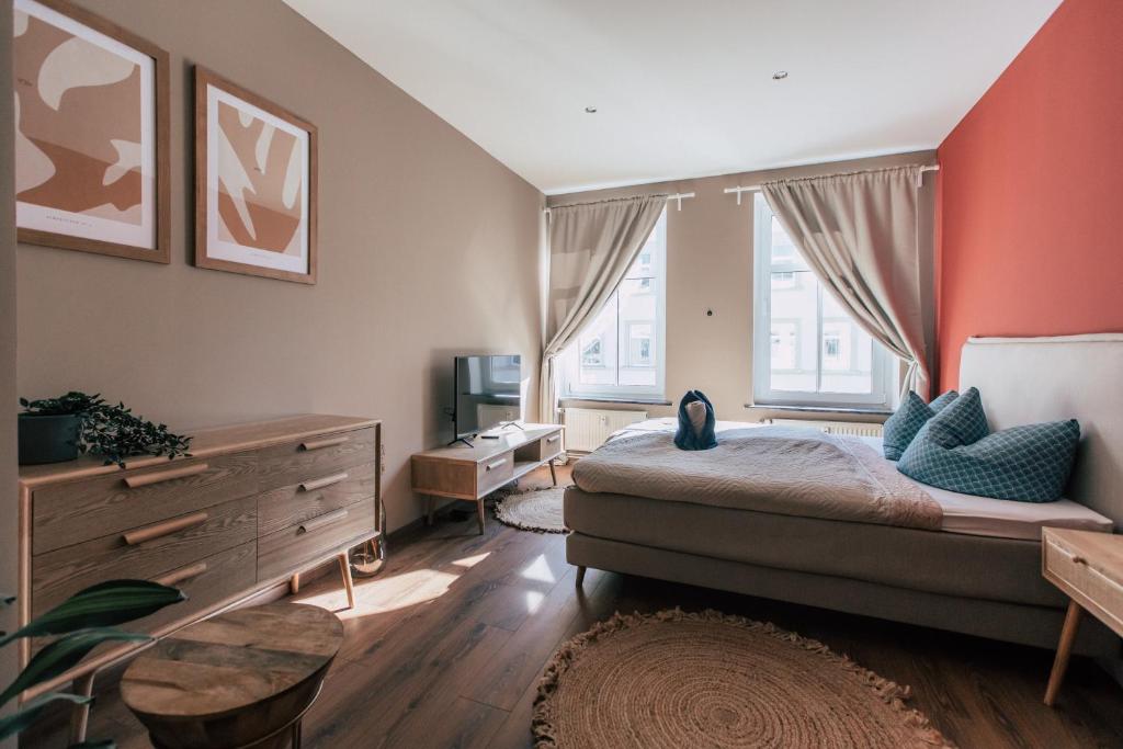 a bedroom with a large bed and a television at Luga Homes - Mitte in Leipzig