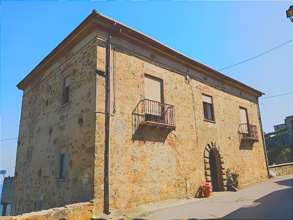 un antiguo edificio de ladrillo con 2 balcones en una calle en B&B La Quercia del Cilento, en Rocca Cilento