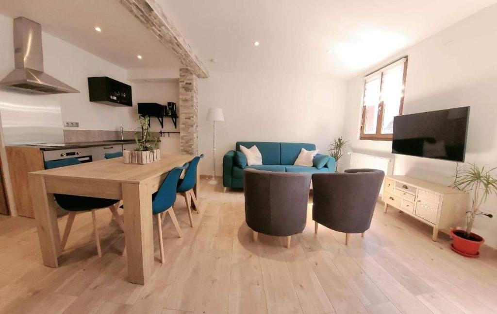 ein Wohnzimmer mit einem Tisch und Stühlen sowie eine Küche in der Unterkunft Gîte Emeraude in Bergheim