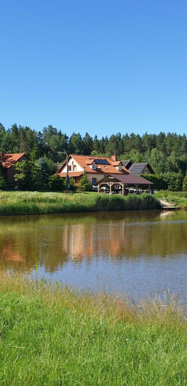 una casa junto a un cuerpo de agua en Siedlisko Pod Dębem, en Wilimy