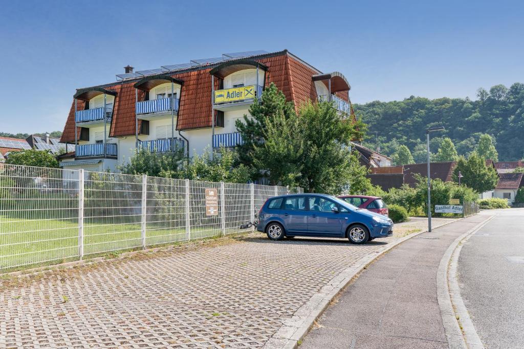 ein blaues Auto, das vor einem Gebäude parkt in der Unterkunft Hotel Adler mit Gasthaus in Haßmersheim