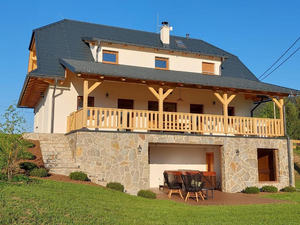 ein großes weißes Haus mit einer Terrasse und einem Tisch in der Unterkunft CHALUPA U ROUBÍČKŮ in Horní Bečva