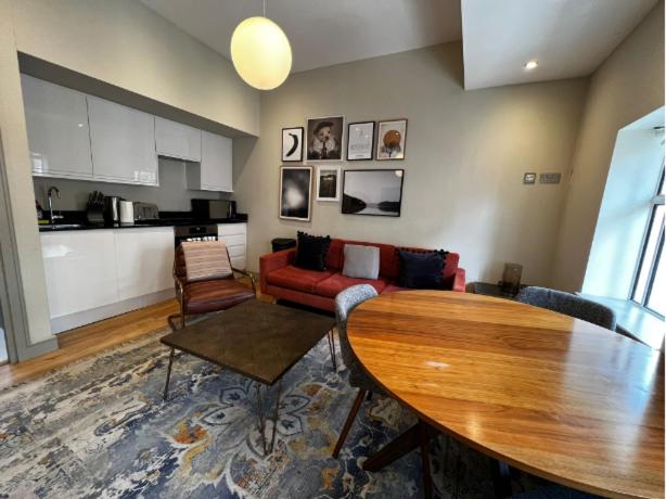 a living room with a red couch and a table at The Soho Loft - Elegant & Modern 1BDR in London