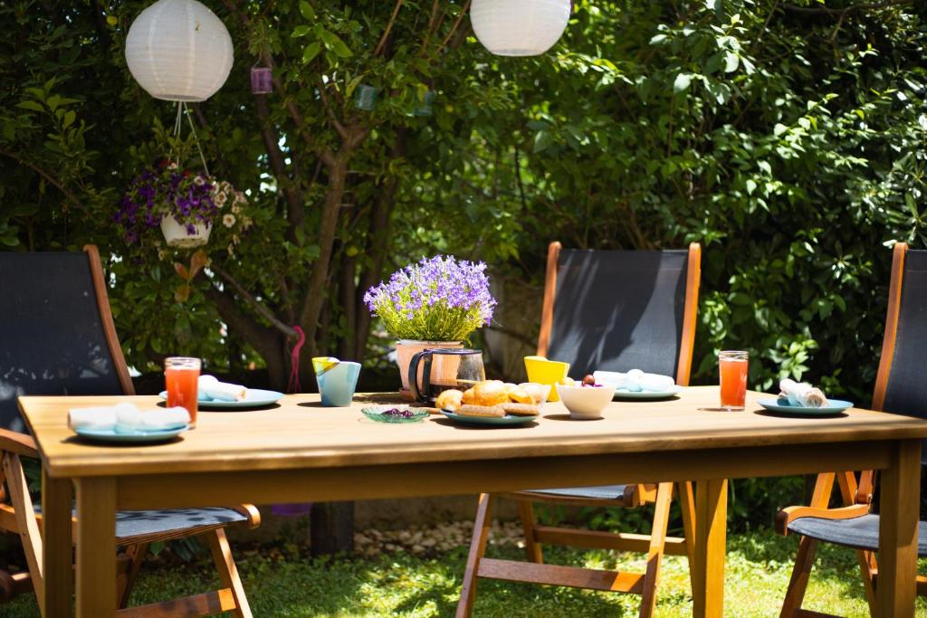 - une table en bois avec de la nourriture dans un jardin dans l'établissement Relaxing family house with garden in Avra, Rafina, à Rafína