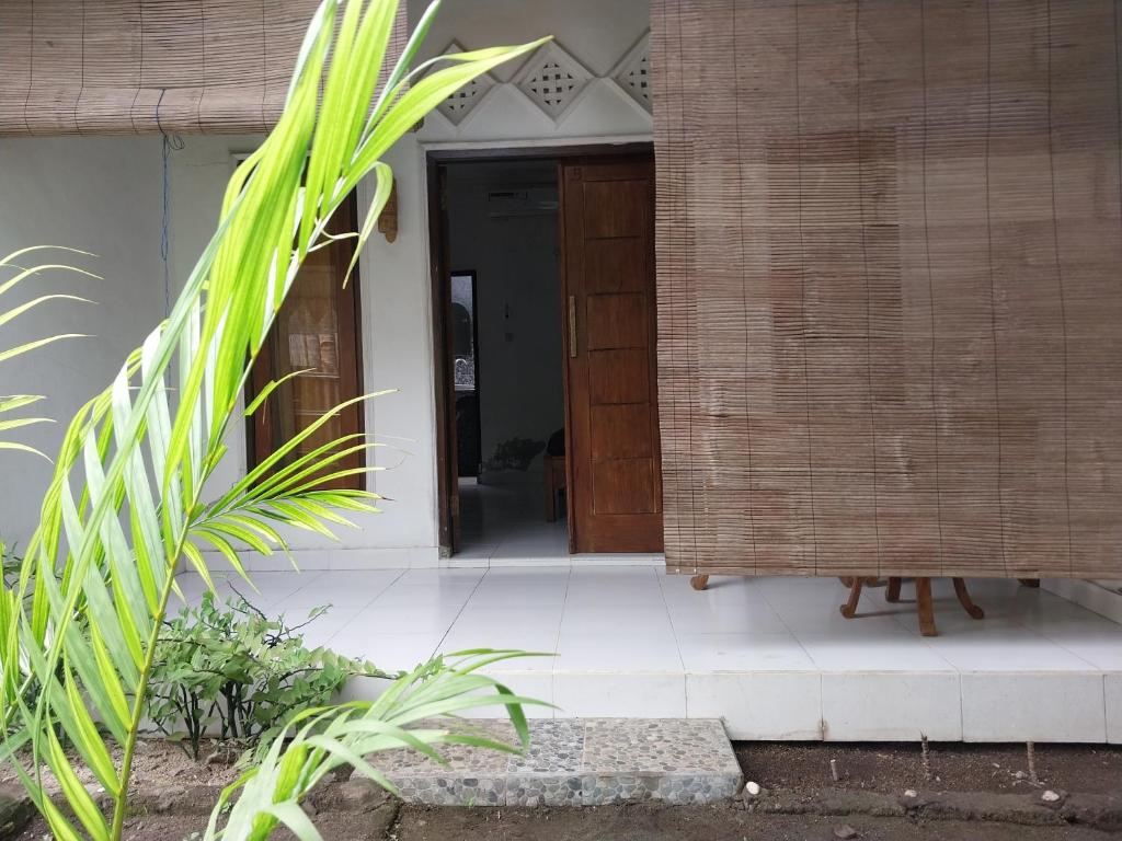 a front door of a house with a plant at Lombok Collection Gili Air in Gili Islands