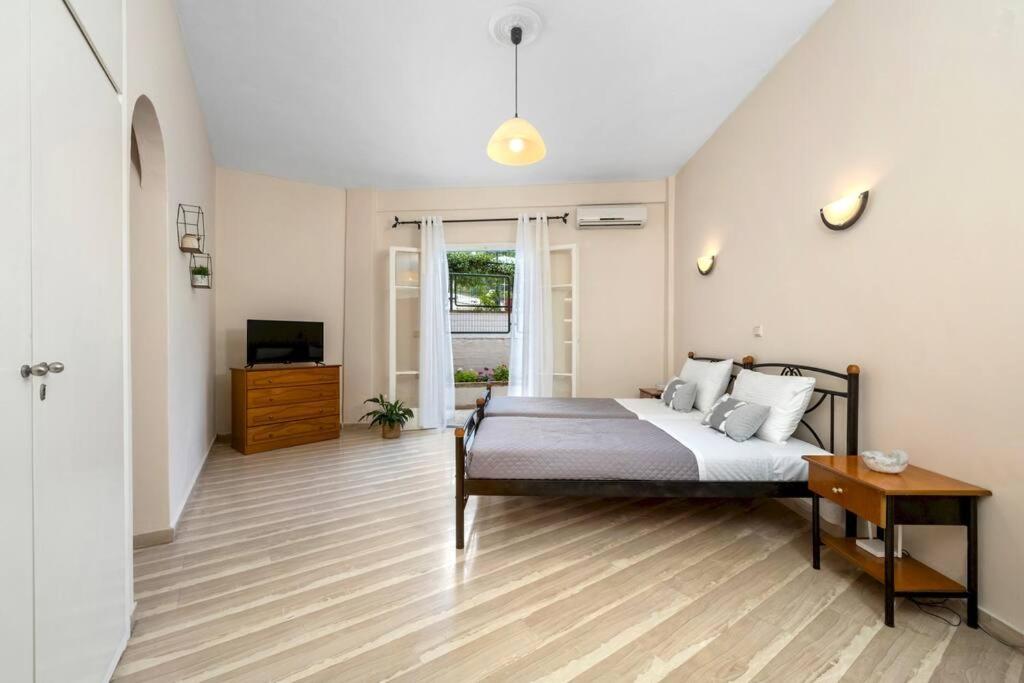 um quarto com uma cama e uma televisão em Aristo Apartment by Estia em Benitses