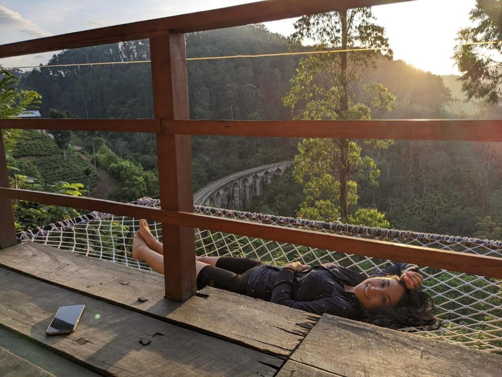 a woman laying on a suspension bridge in the mountains at Barn Hills in Ella