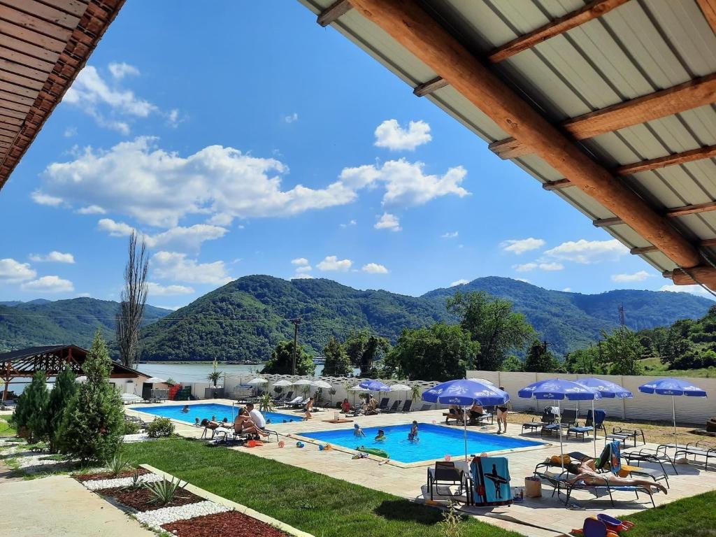 a view of a swimming pool with mountains in the background at Clisura Dunarii - Pensiunea Casa Creta in Liborajdea