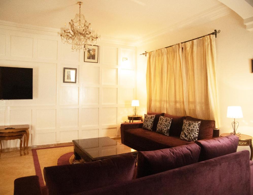 Villa Sabah في مراكش: غرفة معيشة مع أريكة وثريا