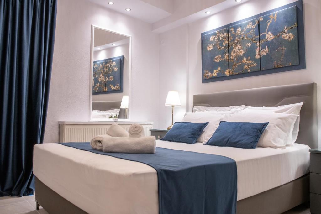 a bedroom with a large bed with blue and white pillows at Mystique in Komotini