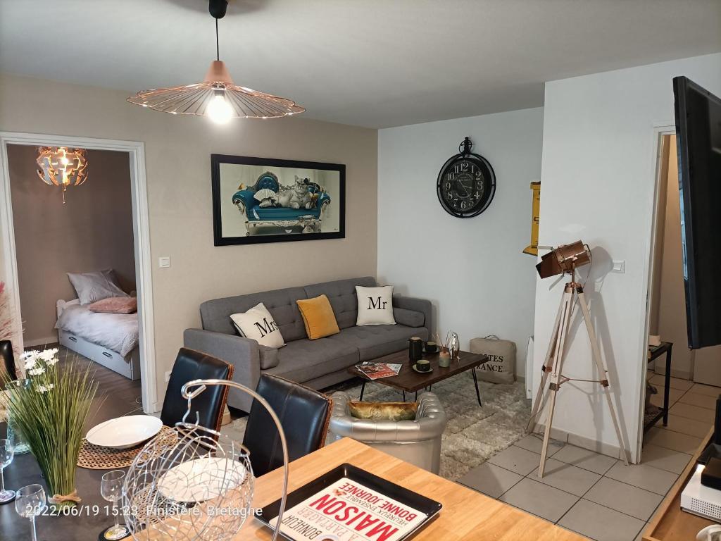 a living room with a couch and a table at L'escale N°13 :Appartement standing dans résidence in Brest