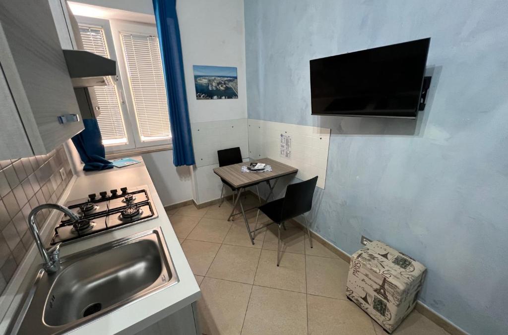 una piccola cucina con lavandino e tavolo di B&B Le Onde Del Mare a Gallipoli